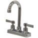 A chrome Advance Tabco deck-mounted gooseneck faucet with two handles on a counter.