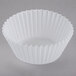 A white fluted baking cup on a white background.
