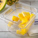 A Carlisle clear plastic food pan drain tray filled with pineapple slices.