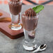 Two Libbey Spirit Shot Glasses filled with chocolate pudding and a leaf of mint.
