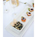 A Tuxton white rectangular china platter with food and wine on it on a table.