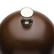 A close up of a metal knob on a Chef Specialties Monarch Walnut Pepper Mill.