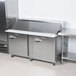 A large stainless steel Traulsen refrigerator with two right hinged doors over a food prep station.
