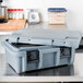 A granite gray plastic top-loading container with a lid on a counter.