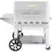 A stainless steel Crown Verity grill with wheels and a roll dome cover.