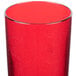 A close up of a red Cambro Del Mar plastic tumbler with a cracked surface.