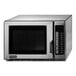An Amana silver stainless steel microwave with a black door.