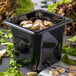 A black Carlisle plastic food pan with mushrooms in it.