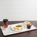 A white Cambro dietary tray with pancakes, sausages, and a cup of coffee.