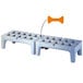 A Metro bow tie dunnage rack with two plastic steps and a white bench.