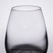 A close up of a Libbey clear spirits glass with a black rim.