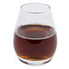 A Libbey Spirits Glass filled with brown liquid on a white background.