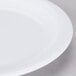 A close up of a Carlisle white melamine plate with a white rim.