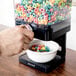 A person pouring cereal into a bowl from a Zevro dry food dispenser.