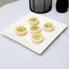 A plate of mini quiches on a white Arcoroc porcelain plate.