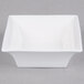 An Arcoroc white square bowl with a curved edge.