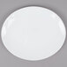 A Tuxton bright white china oval platter on a gray surface.