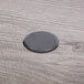 A black circle on a wooden table surface.