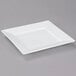 A white square Arcoroc Porcelain plate on a gray surface.