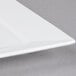 A close up of a white Arcoroc square porcelain plate.