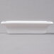 An Arcoroc white rectangular bowl with a small handle on a gray surface.
