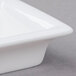 An Arcoroc white rectangular bowl with a lid on it.