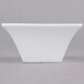 A white square Arcoroc flared bowl on a gray surface.