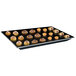 A Hatco black heated glass shelf with pastries on it.