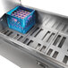 A Traulsen stainless steel milk cooler with a blue crate inside.