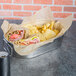 EcoCraft deli wrap covering a metal container with a sandwich and chips inside.