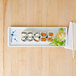 A blue and white Thunder Group Blue Bamboo melamine sandwich tray with sushi and chopsticks on a wood table.