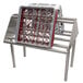 An Advance Tabco double-sided metal rack with slanted tubular shelves holding plastic baskets.