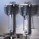 A Hamilton Beach stainless steel drink mixer spindle attached to a stainless steel counter.