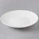 A white porcelain shallow coupe bowl with a white rim.