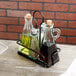 A Tablecraft Marbella metal rack holding glass bottles of oil and vinegar.