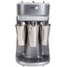 A silver Hamilton Beach triple spindle drink mixer with white cups on top.