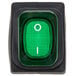A green light switch with a white circle and green push button with the number one.