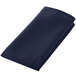 A folded navy blue cloth napkin on a white background.