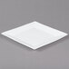 A white square porcelain platter with a white rim on a gray surface.
