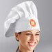 A woman wearing a white Choice customizable chef hat.