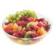 A clear acrylic bowl of fruit salad with strawberries and grapes.