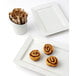 A TuxTrendz bright white rectangular china plate with two cinnamon rolls on it and a spoon next to a cup of coffee.