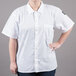 A woman wearing a white Chef Revival short sleeve cook shirt.