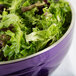 A passion purple Vollrath double wall metal bowl filled with green lettuce.