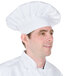 A man wearing a white Chef Revival chef hat with adjustable head band.