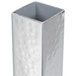 A rectangular silver metal bud vase with a hammered texture and holes in it.