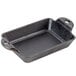 A black Lodge rectangular cast iron casserole dish with two handles on a kitchen counter.