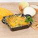 A Lodge mini cast iron casserole dish with cheese and onions.