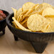Two GET Viva Mexico Molcajete bowls filled with chips and salsa on a table.
