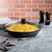 A Lodge cast iron skillet filled with scrambled eggs on a table.